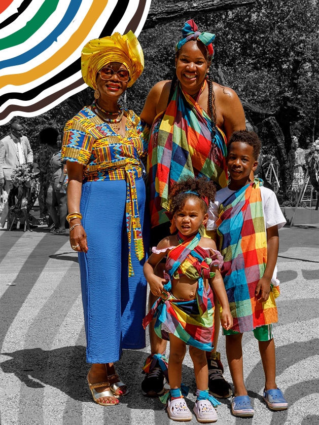 Three generations of a family in vibrant, colorful Afro-Caribbean attire, proudly posing at a cultural commemoration. This image embodies the living legacy and resilience central to HC-SLV's work on slavery history.